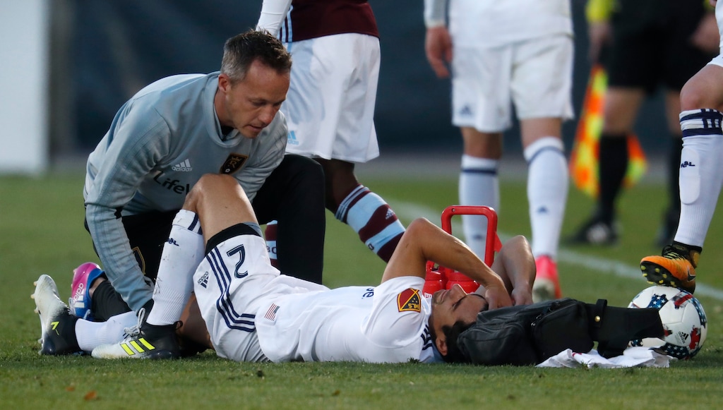 Real Salt Lake defender Tony Beltran, right, rects as he is attended to by a trainer after being injured against the Colorado Rapids in the first half of an MLS soccer match, Sunday, Oct. 15, 2017, in Commerce City, Colo. (AP Photo/David Zalubowski)