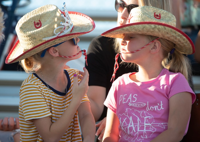 (Rick Egan  |  The Salt Lake Tribune)    Reese Bowen 8, and Holly Weston, 8 try on their new hats as the wait for the rodeo to start, at the West Jordan Western Stampede Rodeo, Saturday, July 6, 2019.