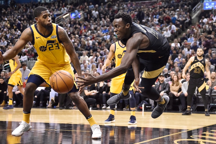 Toronto Raptors forward Pascal Siakam (43) dives to keep the ball next to Utah Jazz forward Royce O'Neale (23) during the second half of an NBA basketball game Friday, Jan. 26, 2018, in Toronto. (Frank Gunn/The Canadian Press via AP)