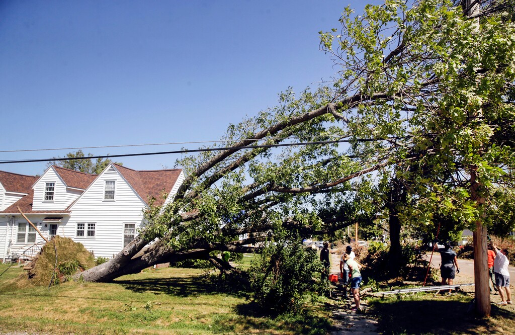 (Jim Slosiarek/The Gazette via AP) Volunteers working with Community Storm Relief Effort clean up storm debris and fallen trees after a derecho earlier this week in Cedar Rapids, Iowa, on Saturday, Aug. 15, 2020.