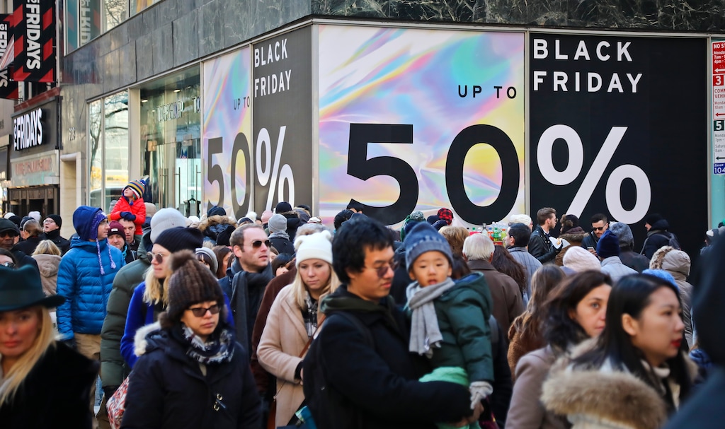 (Bebeto Matthews | AP Photo) Crowds walk past a large store sign displaying a Black Friday discount in midtown Manhattan, Friday, Nov. 23, 2018, in New York. The holiday shopping season presents a big test for a U.S. economy, with overall growth so far this year relying on a burst of consumer spending.