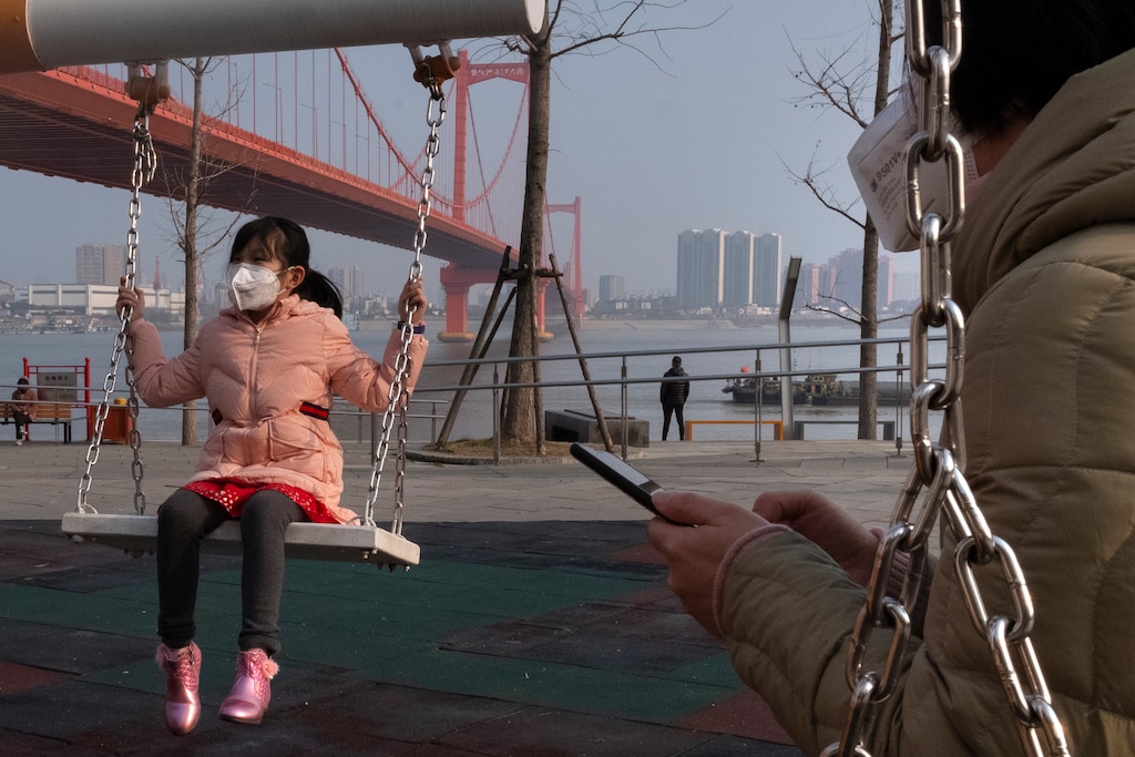 (Arek Rataj | AP) A girl wears a face mask as she play on a swing near the Yingwuzhou Yangtze River Bridge in Wuhan in central China's Hubei Province, Wednesday, Jan. 29, 2020. Countries began evacuating their citizens Wednesday from the Chinese city hardest-hit by a new virus that has now infected more people in China than were sickened in the country by SARS.