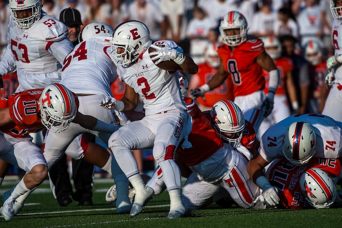 (Chris Detrick  |  The Salt Lake Tribune) East's Sione Molisi (2) runs past Timpview's Payton Madsen (10) during the game at Timpview High School Thursday, August 17, 2017. 