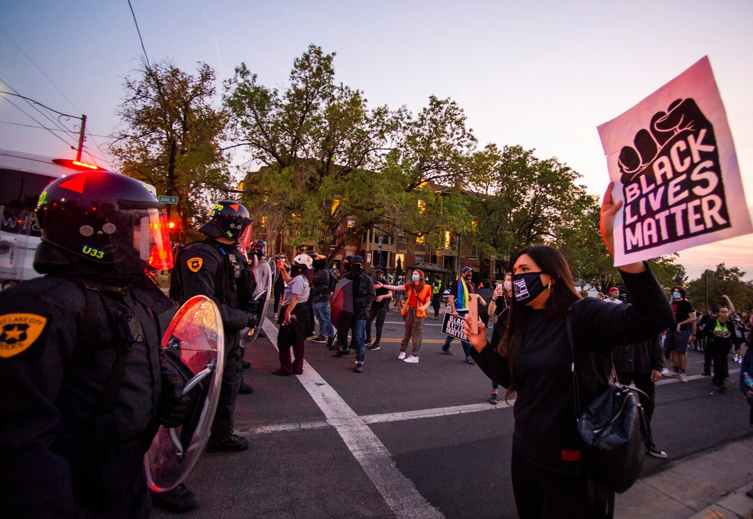 (Rick Egan  |  The Salt Lake Tribune) Jeanette Padilla asks the police why they need riot gear when all protesters have are cardboard signs as a group of protesters face a line of police in riot gear on 1300 East and 200 South, near the University of Utah where Mike Pence is debating Kamala Harris on Wednesday, Oct. 7, 2020.