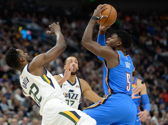 (Francisco Kjolseth  |  The Salt Lake Tribune)  \Utah Jazz forward Jeff Green (22) takes a hit as Oklahoma City Thunder guard Luguentz Dort (5) pushes through to the basket as the Utah Jazz host the Oklahoma City Thunder in their NBA basketball game at Vivint Smart Home Arena in Salt Lake City on Mon. Dec. 9, 2019.