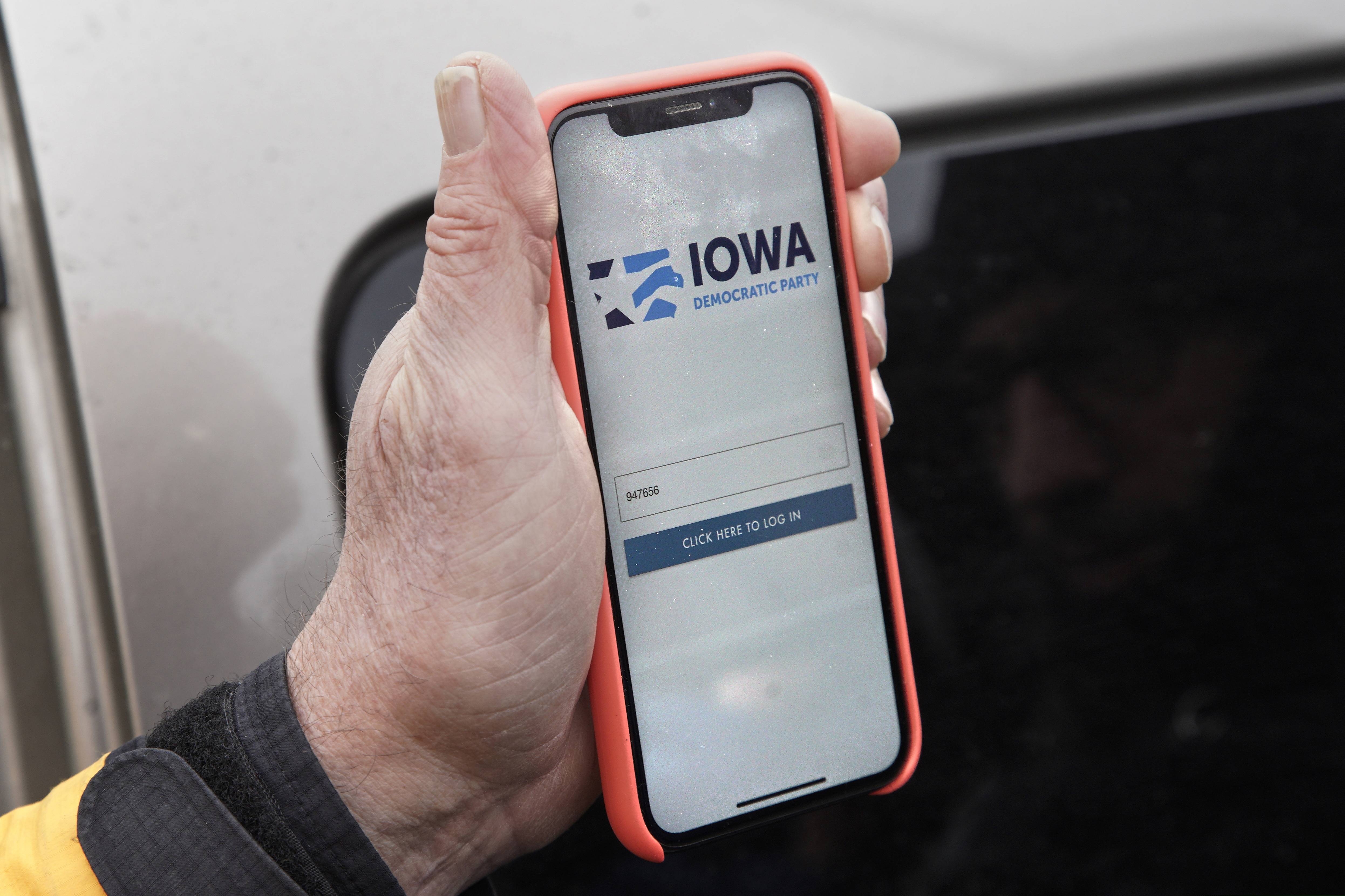 (Nati Harnik | AP) Precinct captain Carl Voss of Des Moines displays the Iowa Democratic Party caucus reporting app on his phone outside of the Iowa Democratic Party headquarters in Des Moines, Iowa, Tuesday, Feb. 4, 2020.