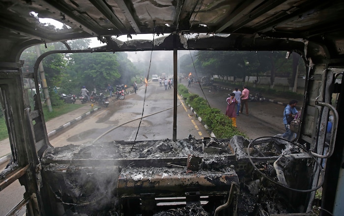 A fire brigade truck burnt by Dera Sacha Sauda sect members lies near Panchkula's court house, India, Friday, Aug. 25, 2017. Deadly riots have broken out in a north Indian town after a court convicted a guru of raping two of his followers. Mobs also attacked journalists and set fire to government buildings and railway stations. (AP Photo/Altaf Qadri)