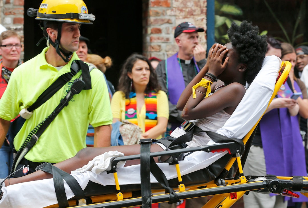 (Steve Helber  |  AP Photo)  Rescue personnel help an injured woman after a car ran into a large group of protesters after an white nationalist rally in Charlottesville, Va., Saturday, Aug. 12, 2017.  The nationalists were holding the rally to protest plans by the city of Charlottesville to remove a statue of Confederate Gen. Robert E. Lee. There were several hundred protesters marching in a long line when the car drove into a group of them.