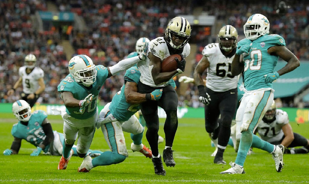 Matt Dunham | The Associated Press. New Orleans Saints running back Alvin Kamara (41) runs past Miami Dolphins defenders to score a touchdown during the second half of an NFL football game at Wembley Stadium in London, Sunday Oct. 1, 2017.