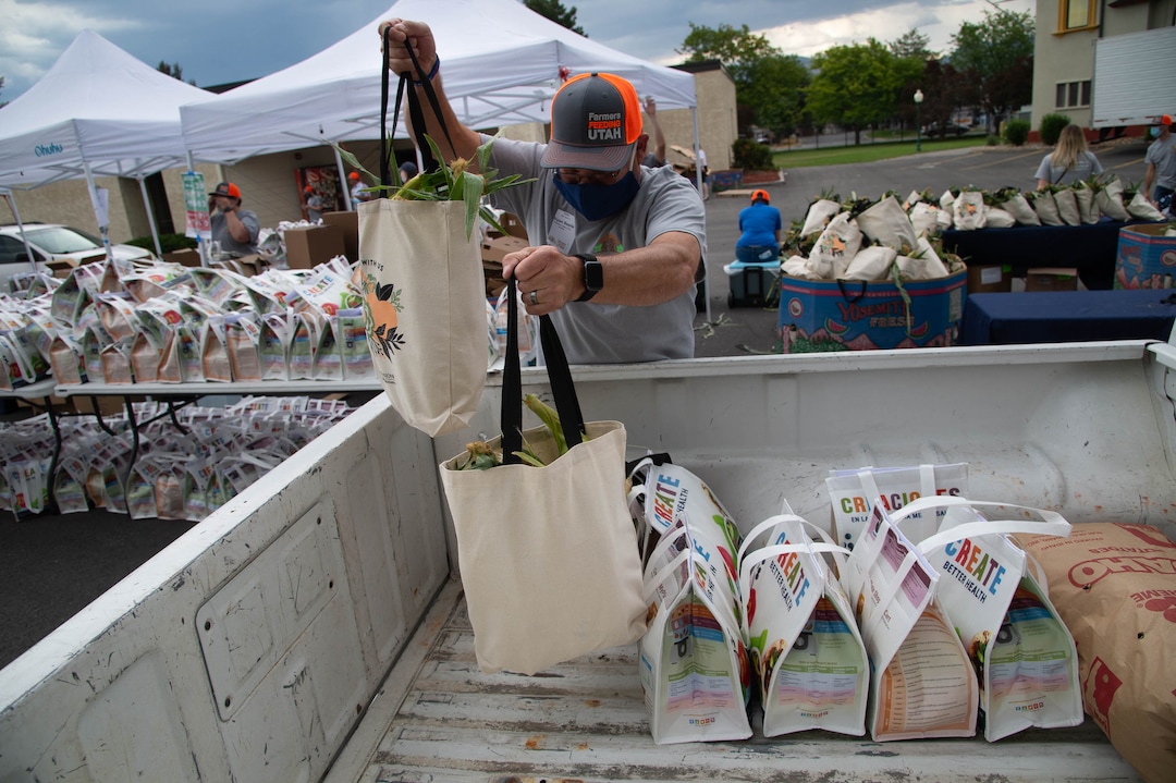 (Francisco Kjolseth  |  The Salt Lake Tribune) Potato farmer Bryan Searle helps load up the back of a pickup truck with food for six families as the third “Miracle Project” for the nonprofit foundation which raises money to purchase food produced by Utah farmers and then gives to residents in need, takes place at the Utah State Fairpark in Salt Lake City on Monday, July 27, 2020. The food donation from the Utah Farm Bureau’s “Farmers Feeding Utah” program provided food for 600 individuals and families who have recently become unemployed due to the coronavirus.