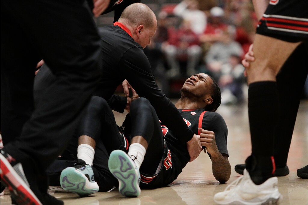 (Young Kwak | AP) A Utah team staff member tends to guard Deivon Smith, who suffered an injury during the first half of an NCAA college basketball game against Washington State, Wednesday, Jan. 24, 2024, in Pullman, Wash.
