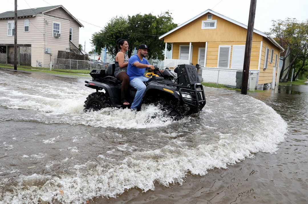 (Jennifer Reynolds | The Galveston County Daily News via AP) Galveston, Texas, residents ride an all terrain vehicle down 50th Street on Saturday, Aug. 26, 2017, as they survey the flooding from Hurricane Harvey in their neighborhood.