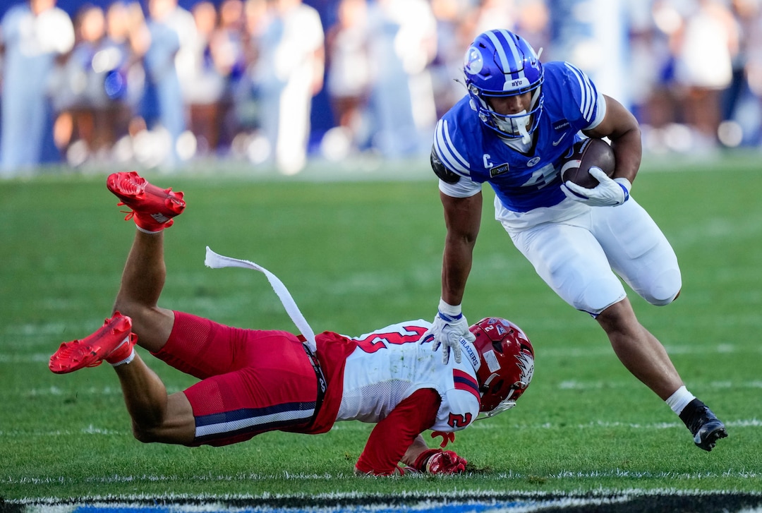 (Francisco Kjolseth | The Salt Lake Tribune) BYU Cougars running back Lj Martin (4) avoids a tackle by Utah Tech Trailblazers safety Brevin Czosnyka (2) during the first half of an NCAA college football game against Utah Tech, Saturday, Sept. 5, 2026, at LaVell Edwards Stadium in Provo.