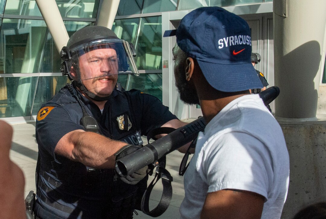 (Rick Egan  |  The Salt Lake Tribune)      A Salt Lake City Policeman reacts as a protester gets a little too close, at the Public Safety Building, during a demonstration, Monday, June 1, 2020.