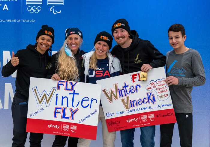 (Rick Egan | The Salt Lake Tribune) Freestyle skier Winter Vinecki, center, poses for photos as she and other Team USA Olympians arrive at the Salt Lake City International Airport on Monday, Feb. 21, 2022.