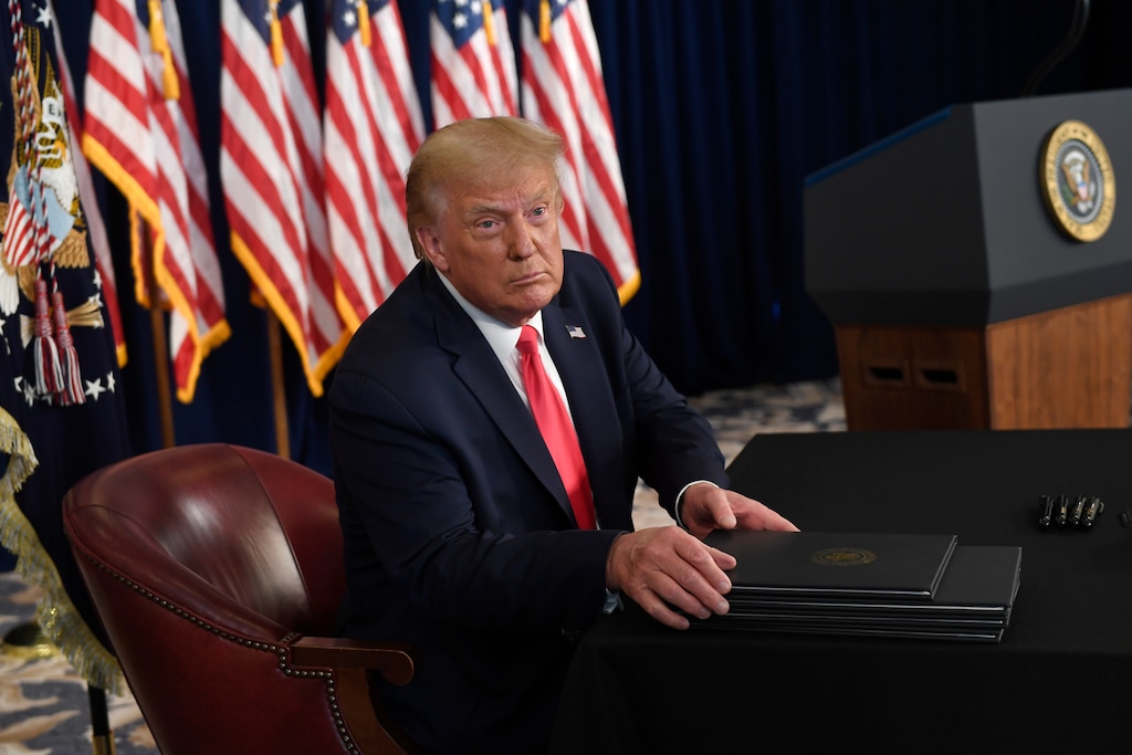 (Susan Walsh | AP file photo)  President Donald Trump prepares to sign four executive orders during a news conference at the Trump National Golf Club in Bedminster, N.J., Saturday, Aug. 8, 2020.