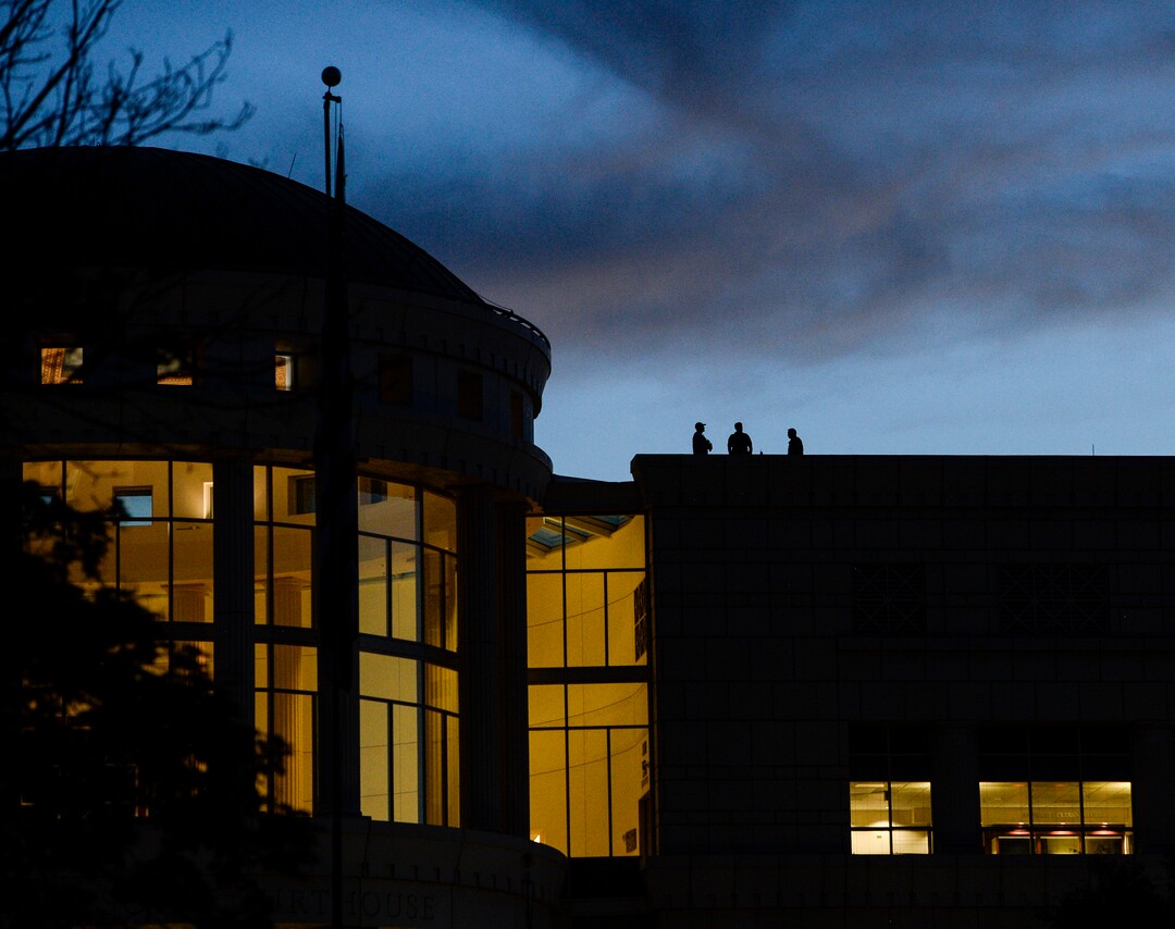 (Leah Hogsten  |  The Salt Lake Tribune) Police watch over the vigil from atop the Scott Matheson Courthouse across State Street during Lights for Liberty: A Vigil to End Human Detention Camps at Washington Square, July 12, 2019 to protest the inhumane conditions faced by refugees.