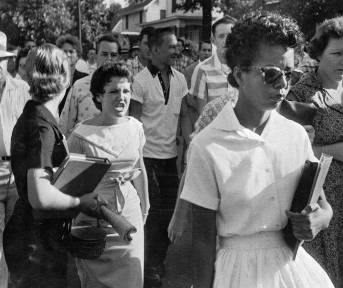 FILE - In this Sept. 4, 1957, file photo, students of Central High School in Little Rock, Ark., including Hazel Bryan, shout insults at Elizabeth Eckford as she calmly walks toward a line of National Guardsmen. The Guardsmen blocked the main entrance and would not let her enter. Monday, Sept. 25, 2017, marks 60 years since the Little Rock Nine first entered the school for classes. (Will Counts/Arkansas Democrat-Gazette via AP, File)