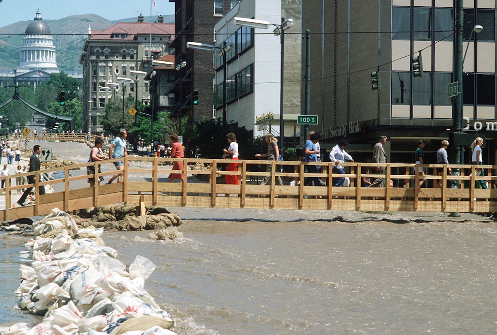 (Al Hartmann | The Salt Lake Tribune) Downtowners made their way across State Street during the 1983 flood via hastily constructed foot bridges. This year's heavy snowpack brings back memories of the 1983 flooding throughout Utah, but past and present public officials think improvements made after the floods should prevent a similar catastrophe.