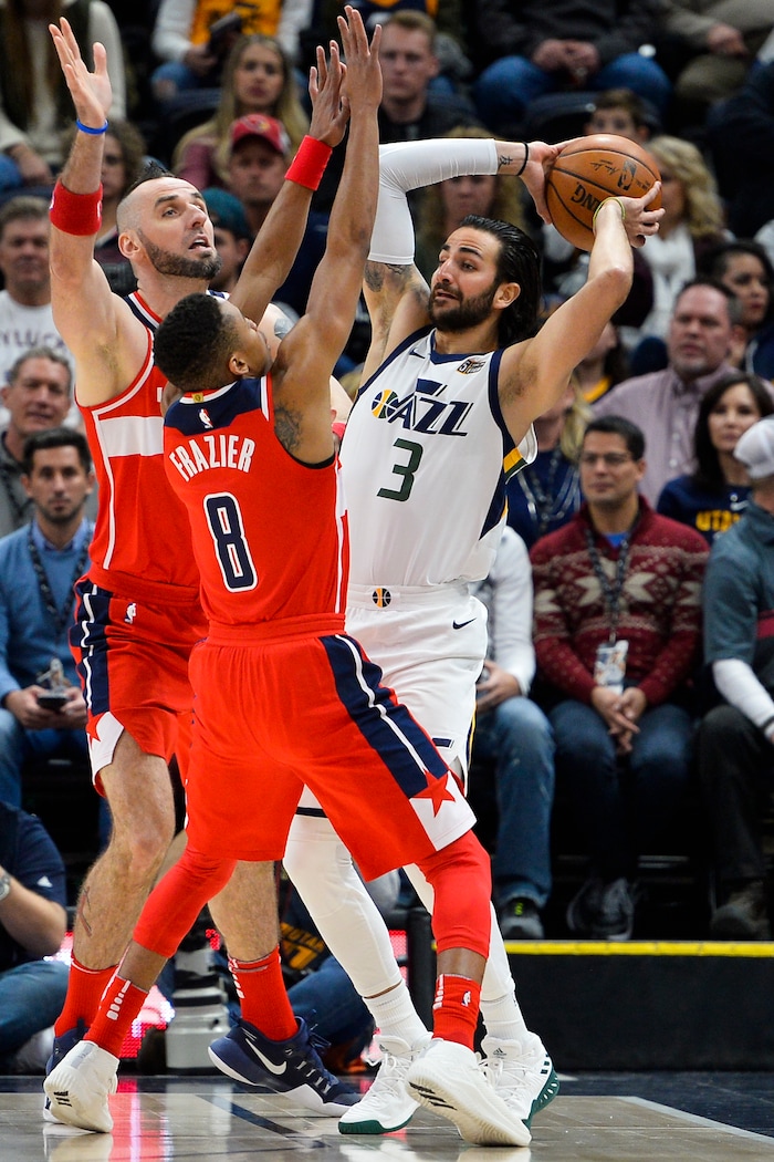 Washington Wizards players Marcin Gortat, left, and Tim Frazier, center, attempt to guard Utah Jazz guard Ricky Rubio, right, in the first half during of an NBA basketball game Monday, Dec. 4, 2017, in Salt Lake City. (AP Photo/Alex Goodlett)