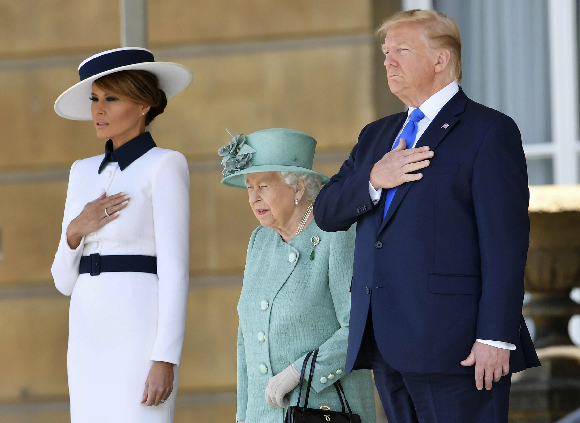 US President Donald Trump and first lady Melania Trump attend a welcome ceremony with Britain's Queen Elizabeth II in the garden of Buckingham Palace, in London, for Monday June 3, 2019, on the first day of a three day state visit to Britain. (Toby Melville/Pool via AP)