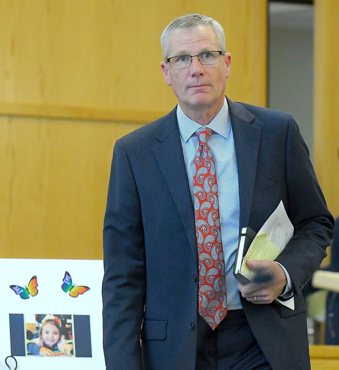 (Eli Lucero  |  Herald Journal) Prosecuting Attorney James Swink walks past a photo of Lizzy Shelley, before Alex Whipple's sentencing hearing in 1st District Court on Tuesday in Logan. Whipple was sentenced to life without the possibility of parole for murdering his niece Lizzy Shelley. 