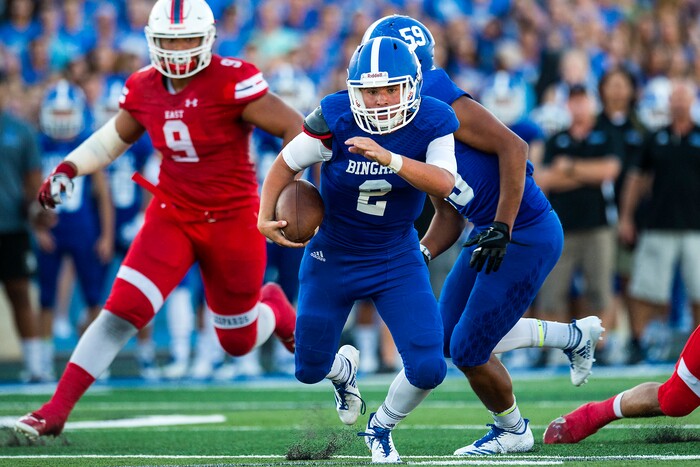 (Chris Detrick  |  The Salt Lake Tribune)  Bingham's Ryan Wood (2) runs past East's Tennessee Pututau (9) during the game at Bingham High School Friday, August 25, 2017. Bingham is winning the game 24-17 at halftime. 