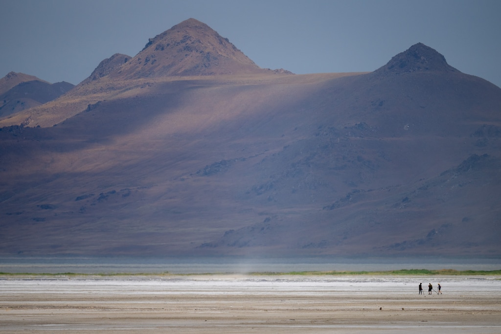 (Trent Nelson  |  The Salt Lake Tribune) Antelope Island looms over hikers at the Great Salt Lake on Saturday, June 18, 2022.