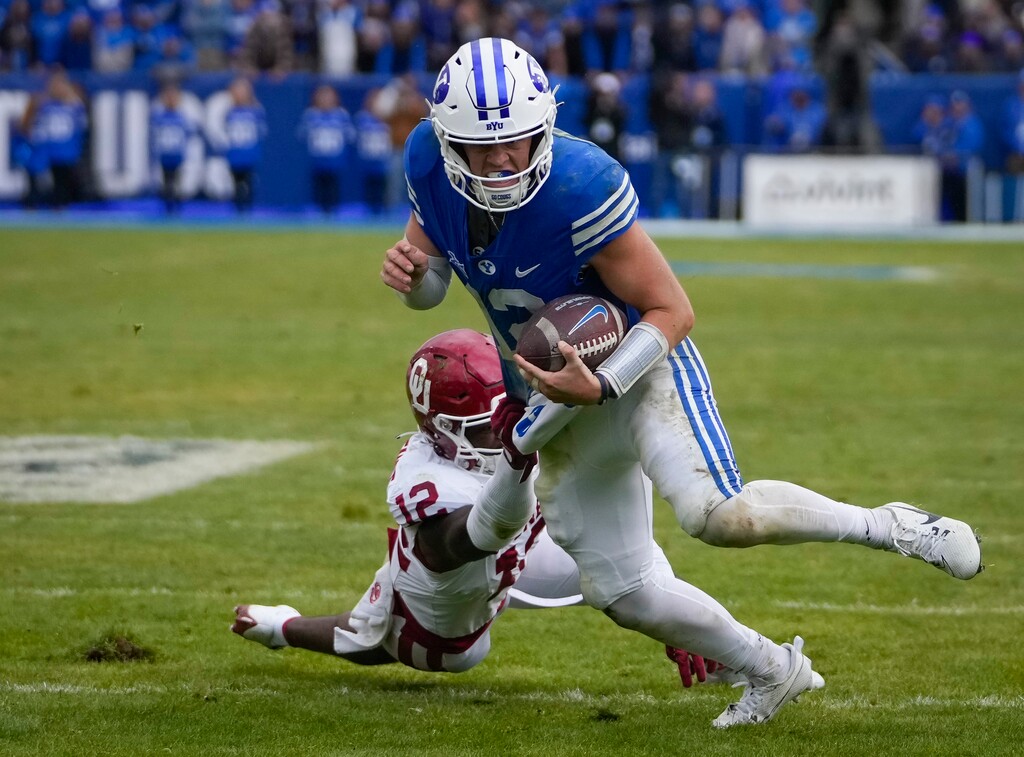 (Bethany Baker | The Salt Lake Tribune) Oklahoma Sooners defensive back Key Lawrence (12) tries to tackle Brigham Young Cougars quarterback Jake Retzlaff (12) before he scores a touchdown at LaVell Edwards Stadium in Provo on Saturday, Nov. 18, 2023.