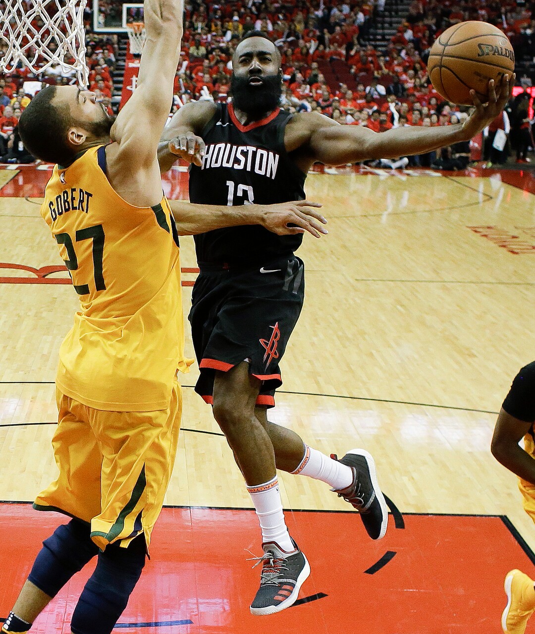 Houston Rockets guard James Harden, right, drives to the basket as Utah Jazz center Rudy Gobert defends during the second half in Game 1 of an NBA basketball second-round playoff series, Sunday, April 29, 2018, in Houston. Houston won 110-96. (AP Photo/Eric Christian Smith)