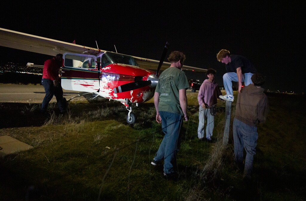 (Bethany Baker  |  The Salt Lake Tribune) Four teenagers hop a fence to assist Utah Highway Patrol push a plane back onto Legacy Parkway to be towed after the plane made an emergency landing near West Bountiful on Sunday, Feb. 15, 2026.