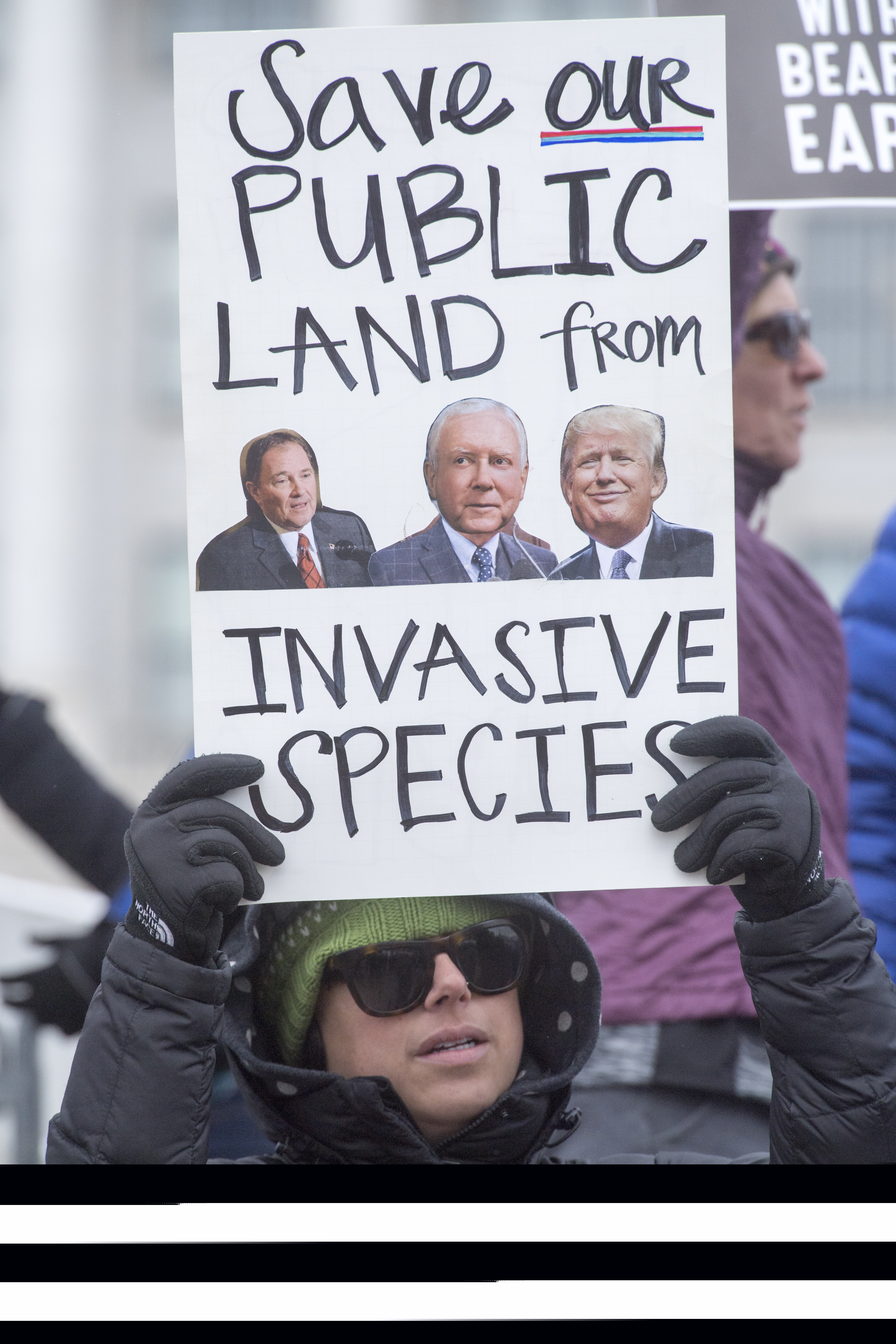 (Rick Egan  |  The Salt Lake Tribune)  Ann Burbidge holds a sign as protesters gather for President Trump's visit to Utah, in front of the Utah State Capitol Building, as he is expected to shrink the Bears Ears and Grand Staircase monuments, iMonday, December 4, 2017.