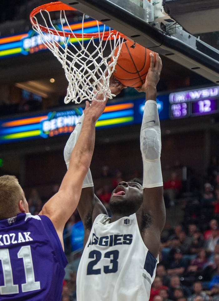 (Rick Egan  |  The Salt Lake Tribune)   Utah State Aggies center Neemias Queta (23) dunks the ball, as Weber State Wildcats forward Michal Kozak (11) defends, in basketball action in the Beehive Classic, between against the Utah State Aggies and Weber State Wildcats, a the Vivint Smart Home Arena, Saturday December 8, 2018.

 
