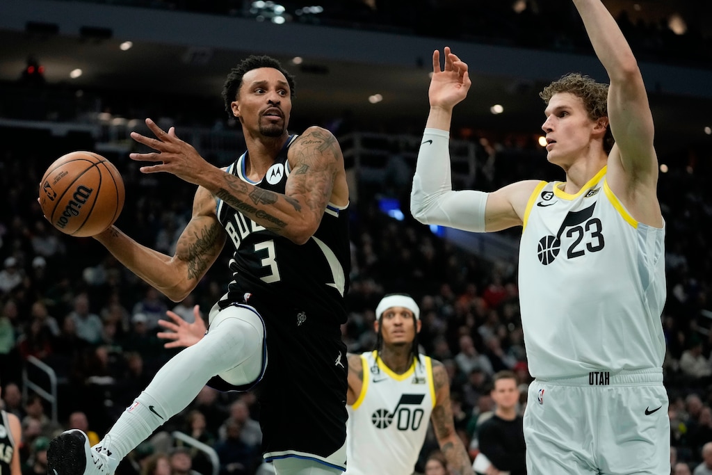 Milwaukee Bucks' George Hill passes around Utah Jazz's Lauri Markkanen during the first half of an NBA basketball game Saturday, Dec. 17, 2022, in Milwaukee. (AP Photo/Morry Gash)