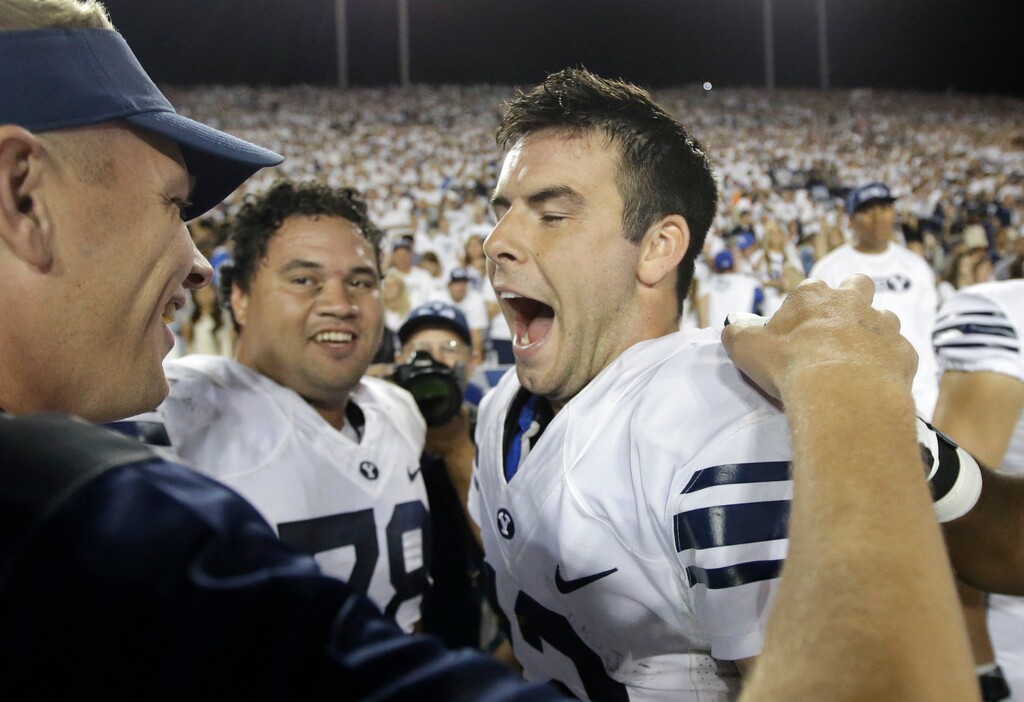 BYU quarterback Tanner Mangum, right, celebrates on the sidelines during the Cougars' 2015 game against Boise State in Provo, Utah. (AP Photo/Rick Bowmer, File)