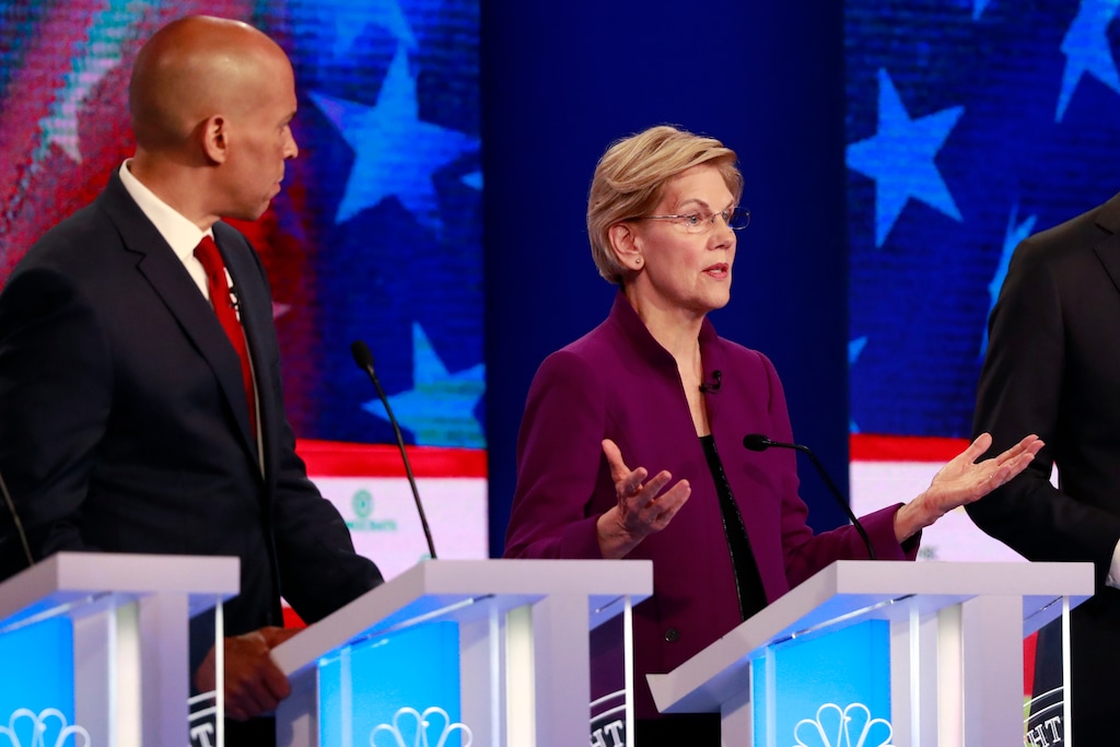 Democratic presidential candidate Sen. Elizabeth Warren, D-Mass., gestures during the Democratic primary debate hosted by NBC News at the Adrienne Arsht Center for the Performing Art, Wednesday, June 26, 2019, in Miami, as Sen. Cory Booker, D-N.J., listens. (AP Photo/Wilfredo Lee)