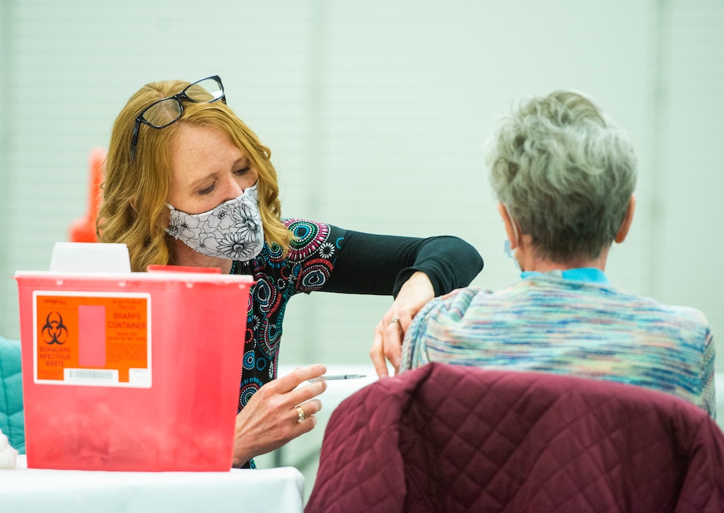 (Rick Egan | The Salt Lake Tribune) Kirsten Weber, gives a COVID-19 vaccination to a Utah County resident in a former Shopko store in Spanish Fork, Wednesday, Jan. 27, 2021.