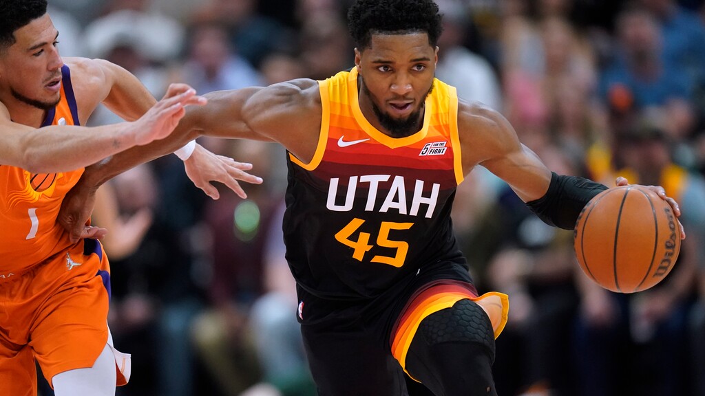 Utah Jazz guard Donovan Mitchell (45) steals the ball from Phoenix Suns guard Devin Booker (1) during the first half of an NBA basketball game Friday, April 8, 2022, in Salt Lake City. (AP Photo/Rick Bowmer)