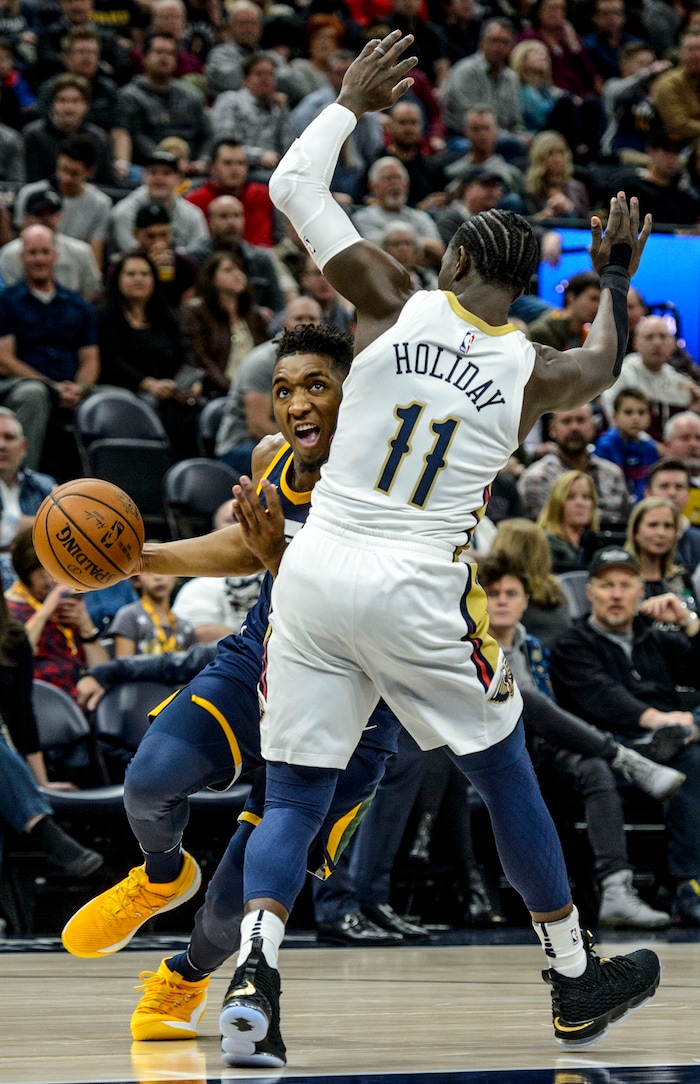(Steve Griffin  |  The Salt Lake Tribune) Utah Jazz guard Donovan Mitchell (45) drives into New Orleans Pelicans guard Jrue Holiday (11) during the the Utah Jazz versus the New Orleans Pelicans NBA basketball game at the Vivint Smart Home Arena in Salt Lake City Wednesday January 3, 2018.