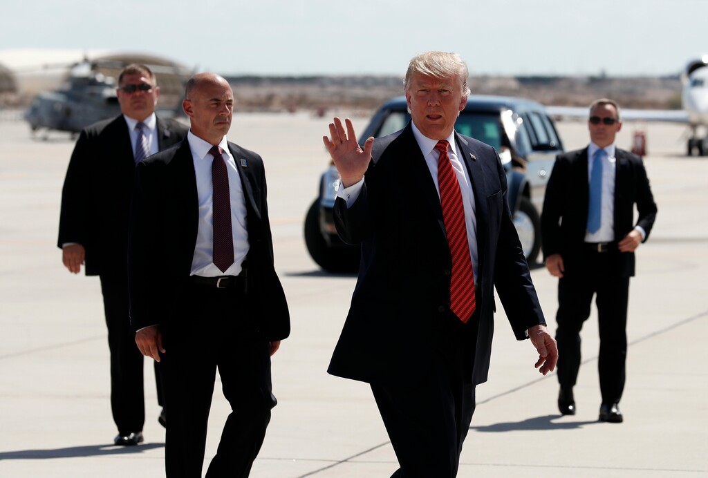 (AP Photo | Alex Brandon, File) In this Tuesday, Aug. 22, 2017, file photo, President Donald Trump walks with his U.S. Secret Service protective detail as he waves before he departs on Air Force One in Yuma, Ariz. Some local officials in the border city of Yuma have expressed disappointment in the brevity of President Trump's visit, which they were hoping would give the community a higher profile on the national stage. The Yuma Sun reports that the initial plans for Trump's visit included a visit to the border and possible meetings with farmers and local politicians, but that didn't happen.