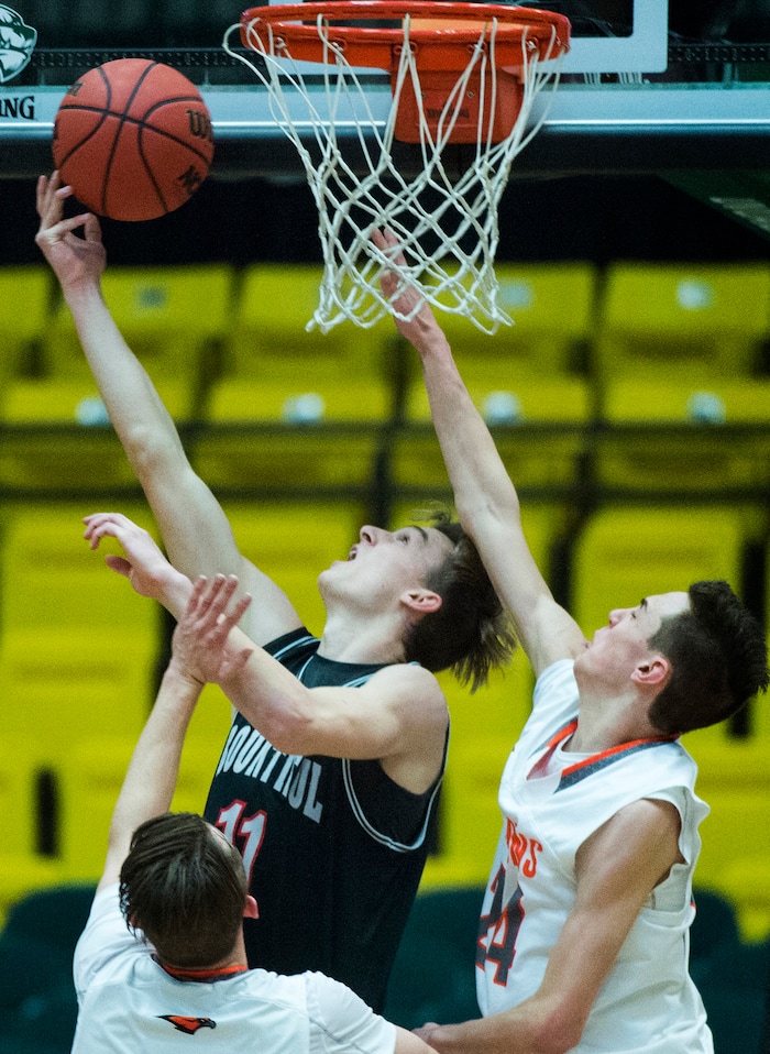 (Rick Egan  |  The Salt Lake Tribune)   Bountiful Braves Garrett Buchanan (11) shoots as Skyridge Falcons Joe White (32) and Skyridge Falcons Trevon Snoddy (24) defend, in 5A basketball playoff action between the Bountiful Braves and Skyridge Falcons, at the UCCU Center in Orem, Monday, Feb. 26, 2018.