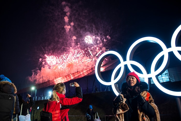(Chris Detrick | The Salt Lake Tribune) People pose for pictures as fireworks explode during the PyeongChang 2018 Olympic Winter Games Closing Ceremony at Olympic Stadium Sunday, Feb. 25, 2018.