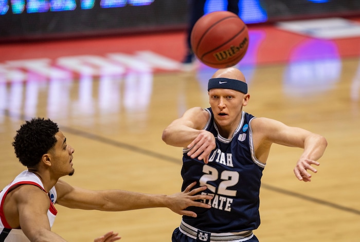 (Doug McSchooler | AP) Utah State guard Brock Miller (22) passes the ball off to a teammate during the first half of a first round game against Texas Tech in the NCAA men's college basketball tournament, Friday, March 19, 2021, in Bloomington, Ind.