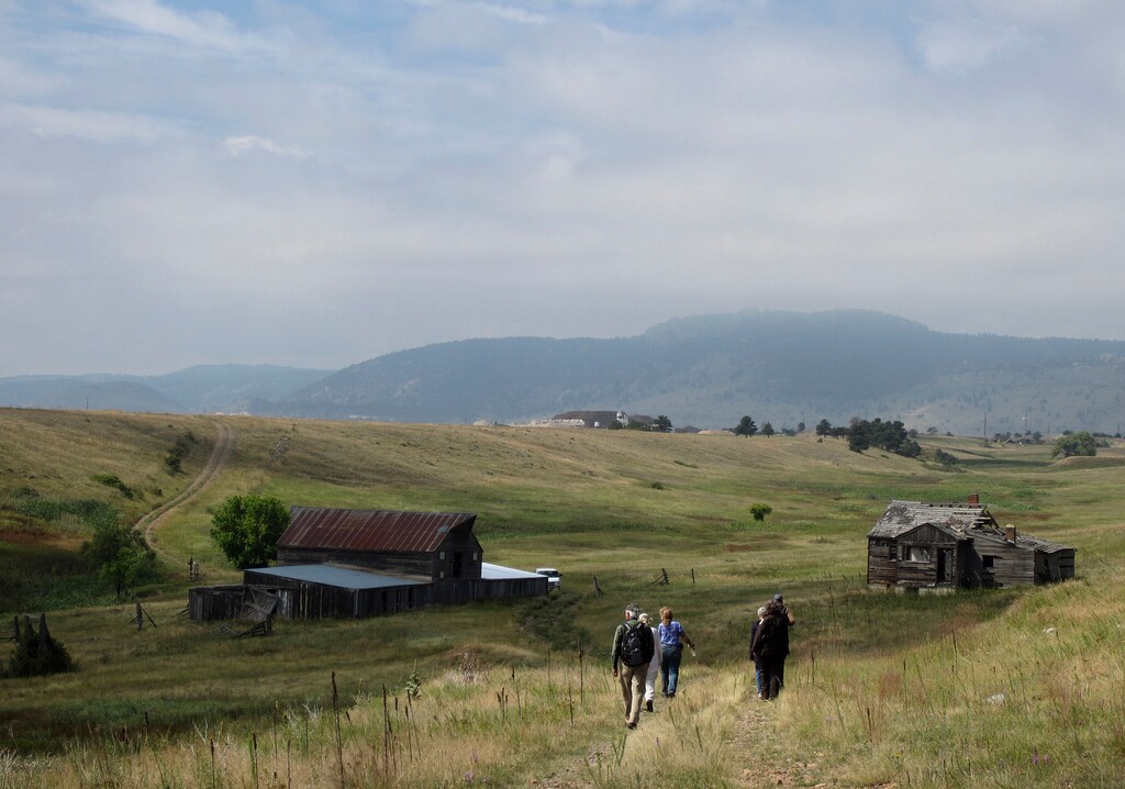 (Dan Elliott | Associated Press file photo) In this Aug. 11, 2017 photo, visitors approach a former ranch house and barn during a guided hike on the Rocky Flats National Wildlife Refuge near Denver. Rocky Flats was once the site of a plant that made plutonium triggers for nuclear weapons. Part of the site was designated a refuge after a $7 billion cleanup. On Sunday, June 3, 2018, the refuge manager harshly criticized a local Colorado health officer who questioned the safety of the site and expressed doubt about whether the U.S. government's assurances about the site could be trusted.