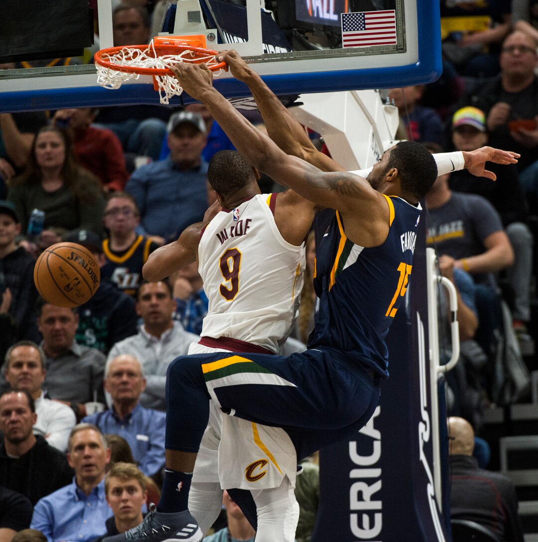 (Rick Egan  |  The Salt Lake Tribune)   Utah Jazz forward Derrick Favors (15) scores as he is fouled by Cleveland Cavaliers guard Dwyane Wade (9), in NBA action Utah Jazz vs Cleveland Cavaliers, in Salt Lake City,  Saturday, December 30, 2017.