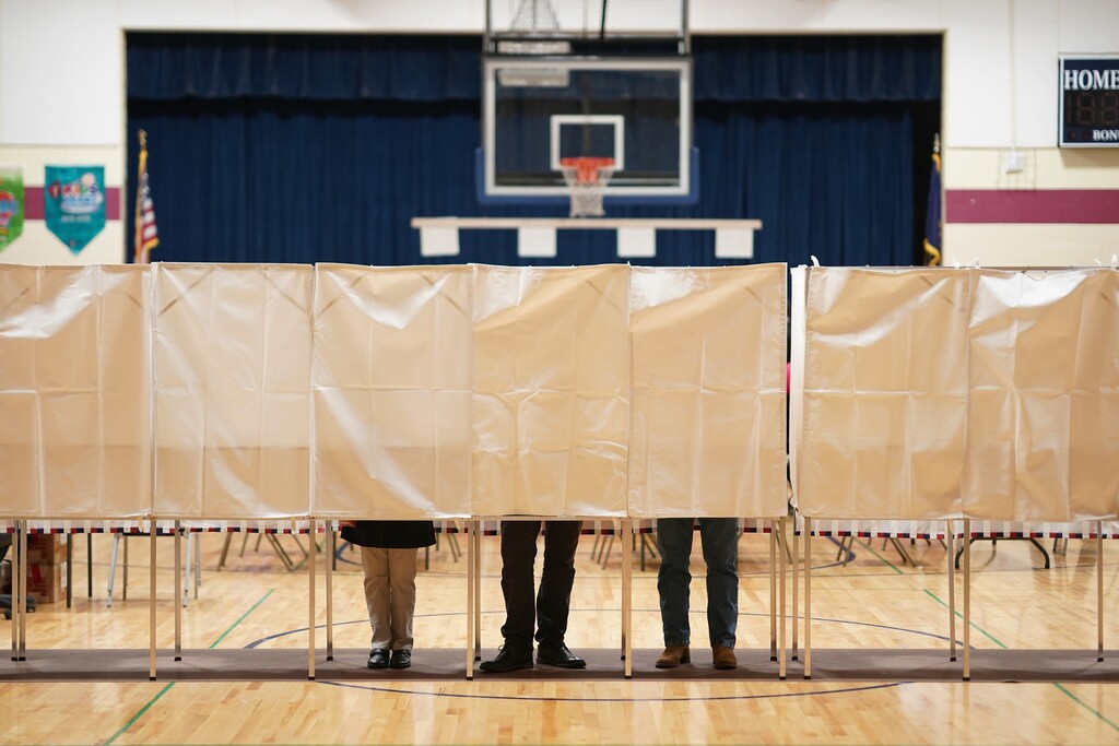 (Chang W. Lee | The New York Times) People vote in the New Hampshire primary at Rye Elementary School in Rye, N.H., on Tuesday, Feb. 11, 2020. A startup says it has developed a smartphone tool through which voters can cast ballots anywhere, but researchers say the app is riddled with security flaws.