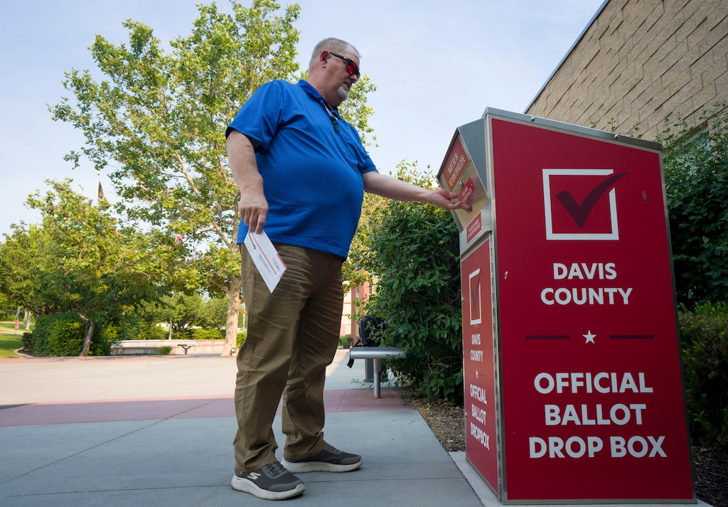 (Bethany Baker  |  The Salt Lake Tribune) A voter drops off a ballot at a ballot drop box at the Davis Conference Center in Layton on Monday, June 22, 2026.