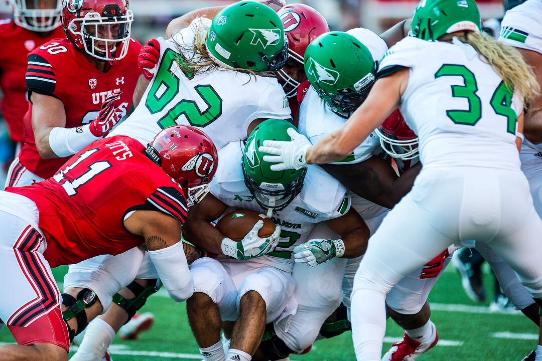 (Chris Detrick  |  The Salt Lake Tribune)  North Dakota Fighting Hawks running back John Santiago (22) is tackled by Utah Utes defensive end Kylie Fitts (11) and other Utah defenders during the game at Rice-Eccles Stadium Thursday, August 31, 2017. Utah Utes are leading North Dakota Fighting Hawks 17-9 at halftime. 