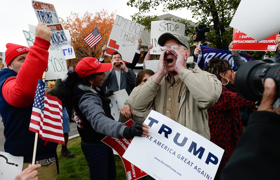 (Francisco Kjolseth | The Salt Lake Tribune)  Two competing rallies spar near Rep. Ben McAdams' office in West Jordan, one seeking to support McAdams and one to criticize him for supporting the impeachment inquiry of President Donald Trump on Wednesday, Oct. 9, 2019, as they try to block one another's signs during a brief moment of confrontation.