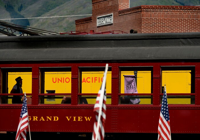 (Leah Hogsten  |  The Salt Lake Tribune) A Heber Valley Railroad employee walks through a passenger train car at the historic railroad in anticipation of an excursion Monday as American flags honor of our military, past and present, men and women who serve or have served in our Armed Forces, May 25, 2020.